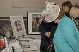 Attendees browsing raffles and silent auction items at Sojourner House's fundraiser Victorian Tea