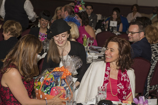 Attendees winning raffles and silent auction items at Sojourner House's fundraiser Victorian Tea