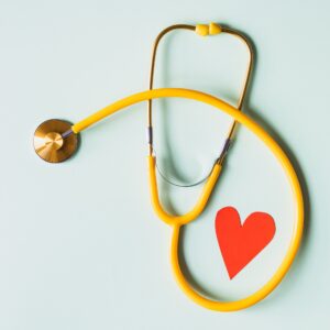 yellow stethoscope circles around red paper heart