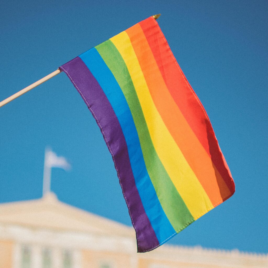 rainbow pride flag being held above a person's head