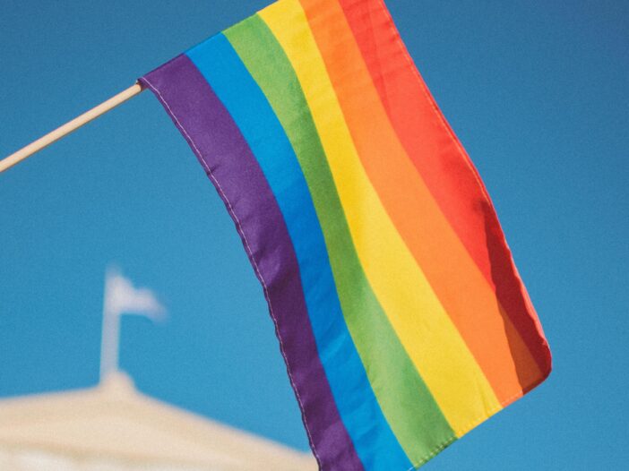 rainbow pride flag being held above a person's head